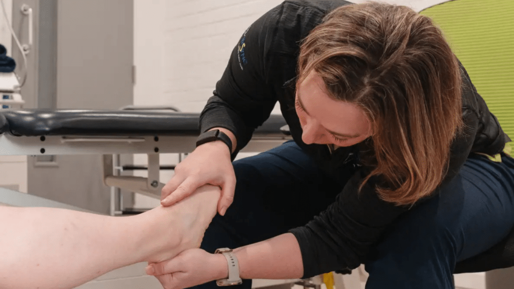 Marathon Training Injuries London: 7 Ways to Stay Race-Ready 1 A physiotherapist assessing a marathon runner for training injuries in London.